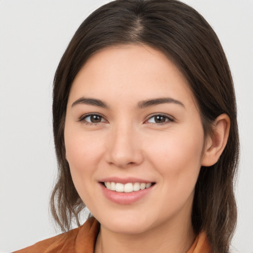 Joyful white young-adult female with long  brown hair and brown eyes