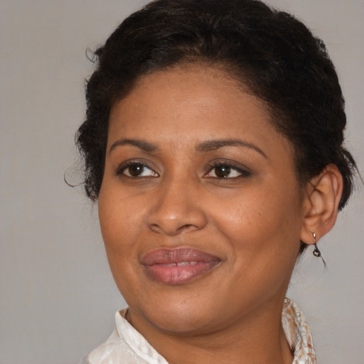 Joyful black adult female with medium  brown hair and brown eyes