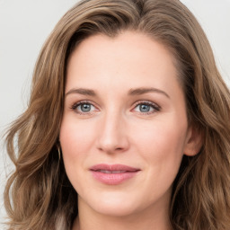 Joyful white young-adult female with long  brown hair and green eyes