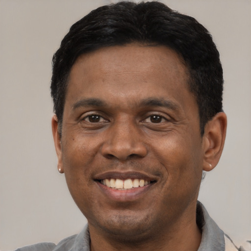 Joyful latino adult male with short  black hair and brown eyes