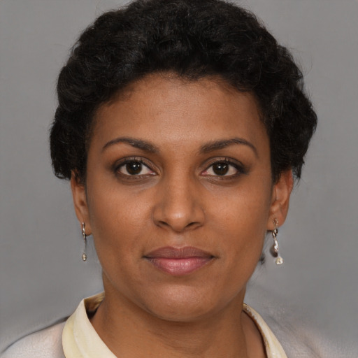 Joyful black young-adult female with short  brown hair and brown eyes