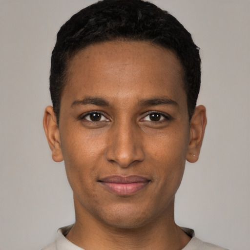 Joyful black young-adult male with short  black hair and brown eyes