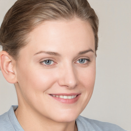 Joyful white young-adult female with short  brown hair and blue eyes