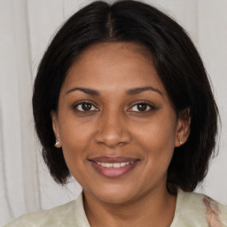 Joyful black young-adult female with medium  brown hair and brown eyes