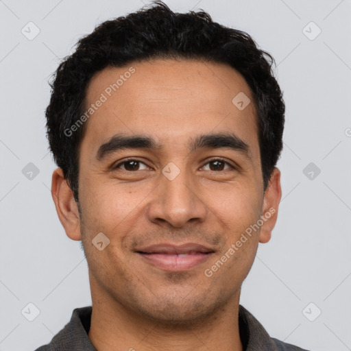 Joyful latino young-adult male with short  black hair and brown eyes