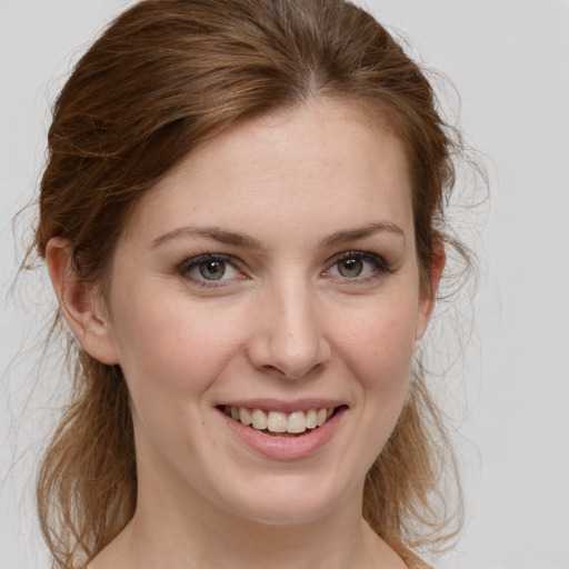 Joyful white young-adult female with medium  brown hair and blue eyes