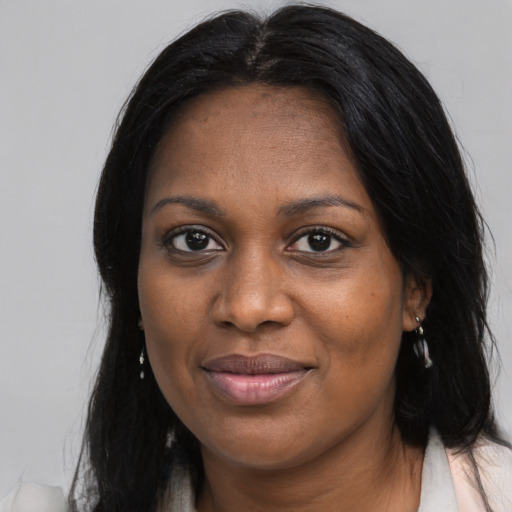 Joyful black young-adult female with long  brown hair and brown eyes