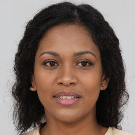 Joyful black young-adult female with long  brown hair and brown eyes