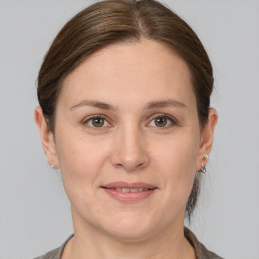 Joyful white young-adult female with medium  brown hair and grey eyes