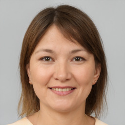 Joyful white young-adult female with medium  brown hair and brown eyes