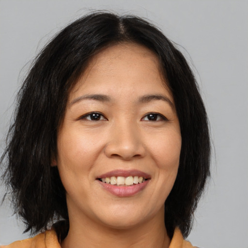 Joyful asian young-adult female with medium  brown hair and brown eyes