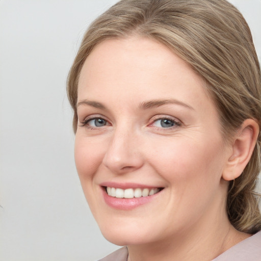 Joyful white young-adult female with medium  brown hair and blue eyes