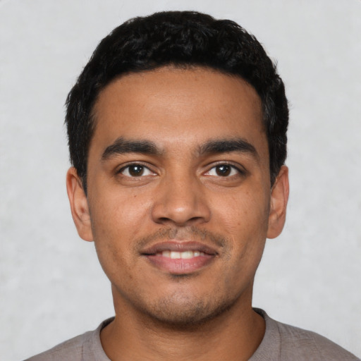 Joyful latino young-adult male with short  black hair and brown eyes