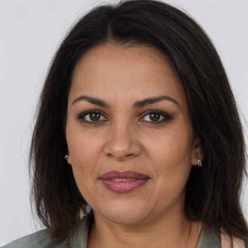 Joyful latino adult female with long  brown hair and brown eyes