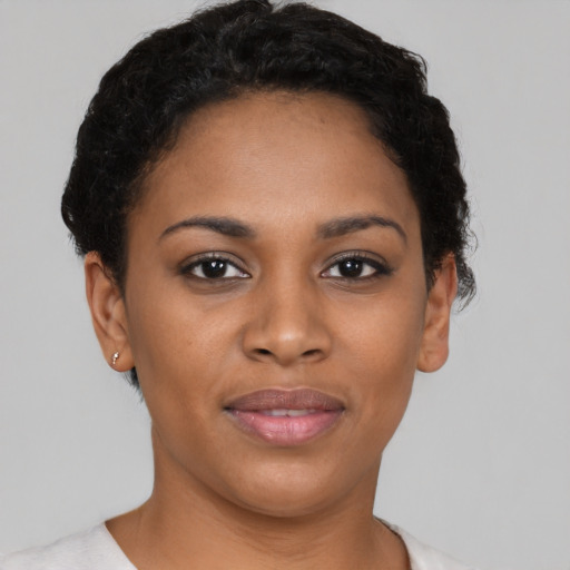 Joyful black young-adult female with short  brown hair and brown eyes
