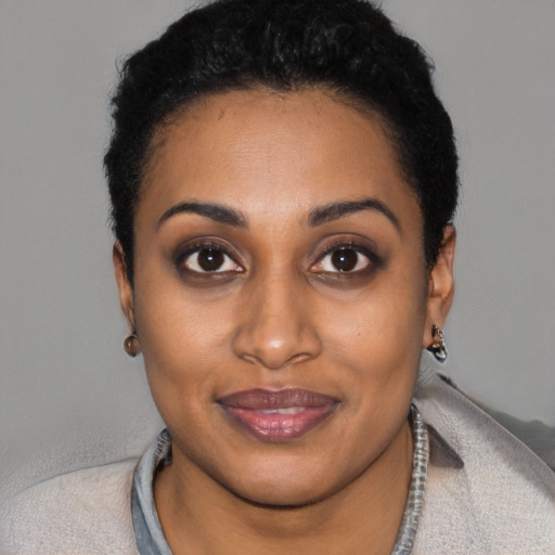 Joyful black young-adult female with short  black hair and brown eyes