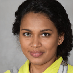 Joyful black young-adult female with medium  brown hair and brown eyes