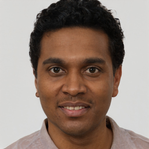 Joyful black young-adult male with short  black hair and brown eyes