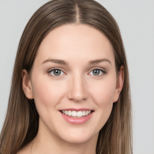 Joyful white young-adult female with long  brown hair and grey eyes