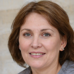 Joyful white adult female with medium  brown hair and grey eyes