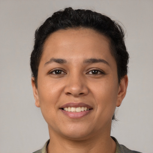 Joyful latino young-adult female with short  black hair and brown eyes