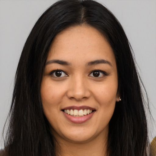 Joyful asian young-adult female with long  brown hair and brown eyes