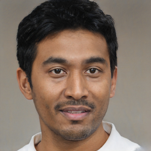 Joyful black young-adult male with short  black hair and brown eyes