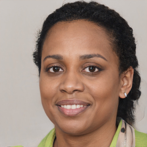Joyful black young-adult female with short  brown hair and brown eyes