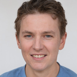 Joyful white adult male with short  brown hair and grey eyes