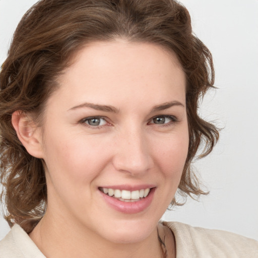 Joyful white young-adult female with medium  brown hair and blue eyes