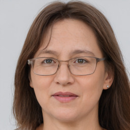 Joyful white adult female with long  brown hair and grey eyes