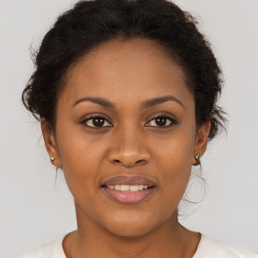 Joyful black young-adult female with short  brown hair and brown eyes