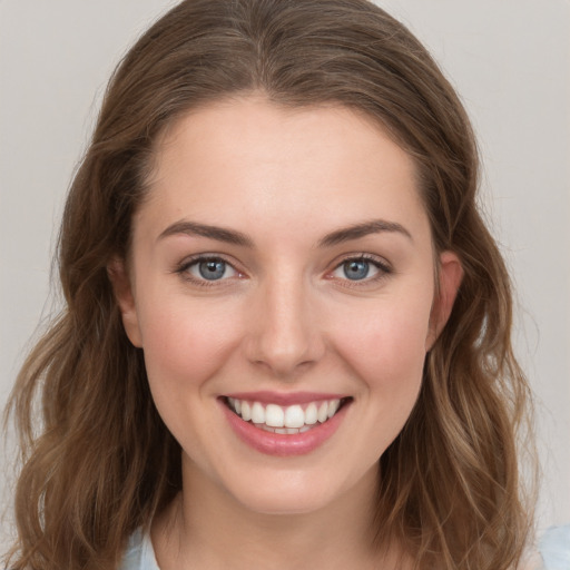 Joyful white young-adult female with long  brown hair and grey eyes