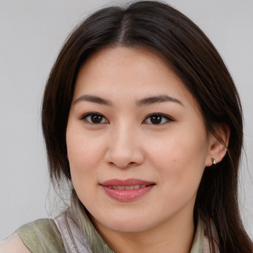 Joyful asian young-adult female with long  brown hair and brown eyes