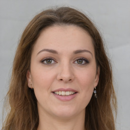 Joyful white young-adult female with long  brown hair and green eyes