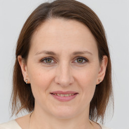 Joyful white adult female with medium  brown hair and grey eyes