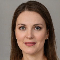 Joyful white young-adult female with long  brown hair and grey eyes