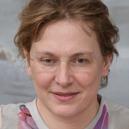 Joyful white adult female with medium  brown hair and blue eyes