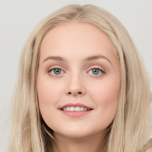 Joyful white young-adult female with long  brown hair and blue eyes