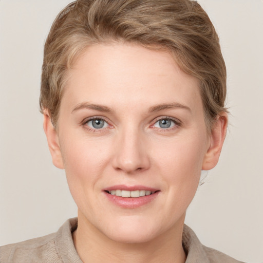 Joyful white young-adult female with short  brown hair and grey eyes