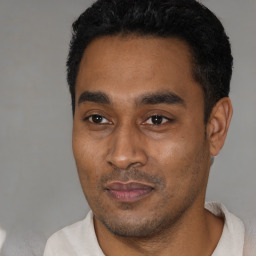 Joyful latino young-adult male with short  black hair and brown eyes