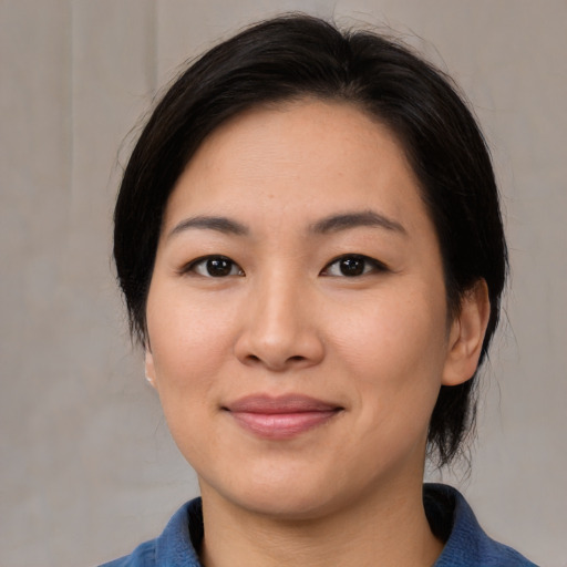 Joyful asian young-adult female with medium  black hair and brown eyes