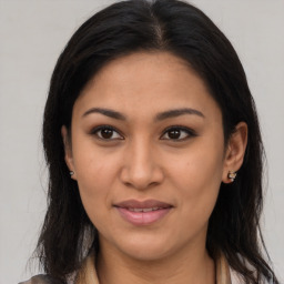 Joyful latino young-adult female with long  brown hair and brown eyes