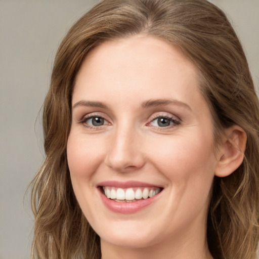 Joyful white young-adult female with long  brown hair and blue eyes