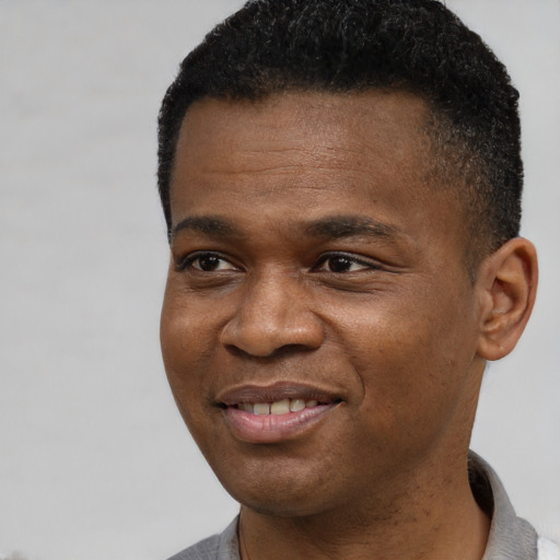 Joyful black young-adult male with short  brown hair and brown eyes