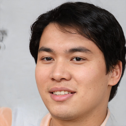 Joyful asian young-adult male with short  brown hair and brown eyes