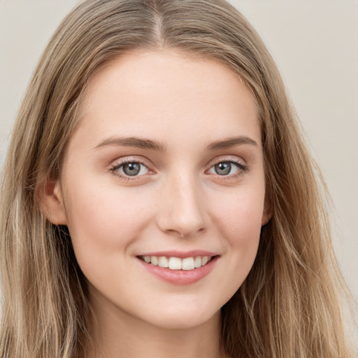 Joyful white young-adult female with long  brown hair and grey eyes