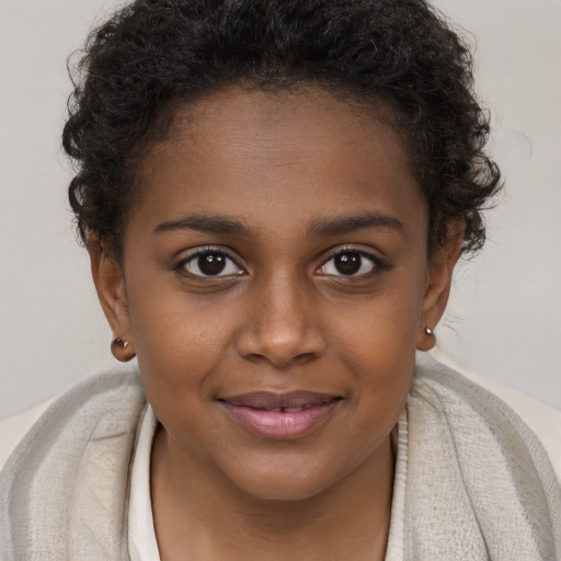 Joyful black young-adult female with short  brown hair and brown eyes