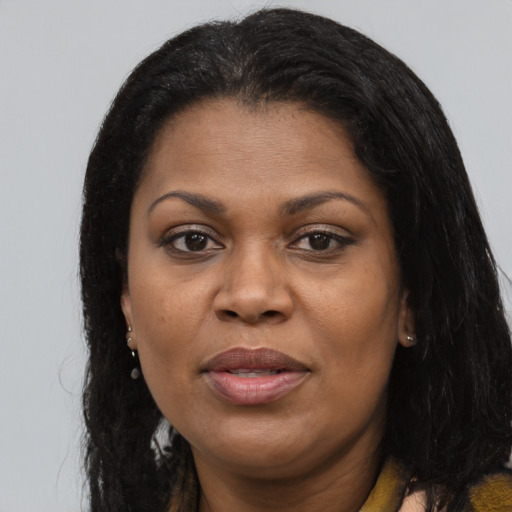 Joyful black adult female with long  brown hair and brown eyes