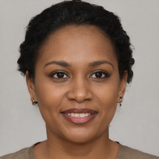 Joyful black young-adult female with short  brown hair and brown eyes